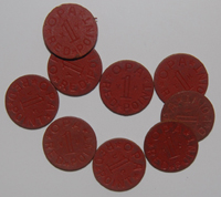 These red cardboard discs are one half inch in diameter and about one sixteenth of an inch thick.