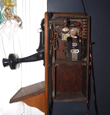 Side of wall phone with hand crank.