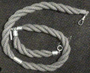 Gold brooch with hair plaited in a crossing pattern.